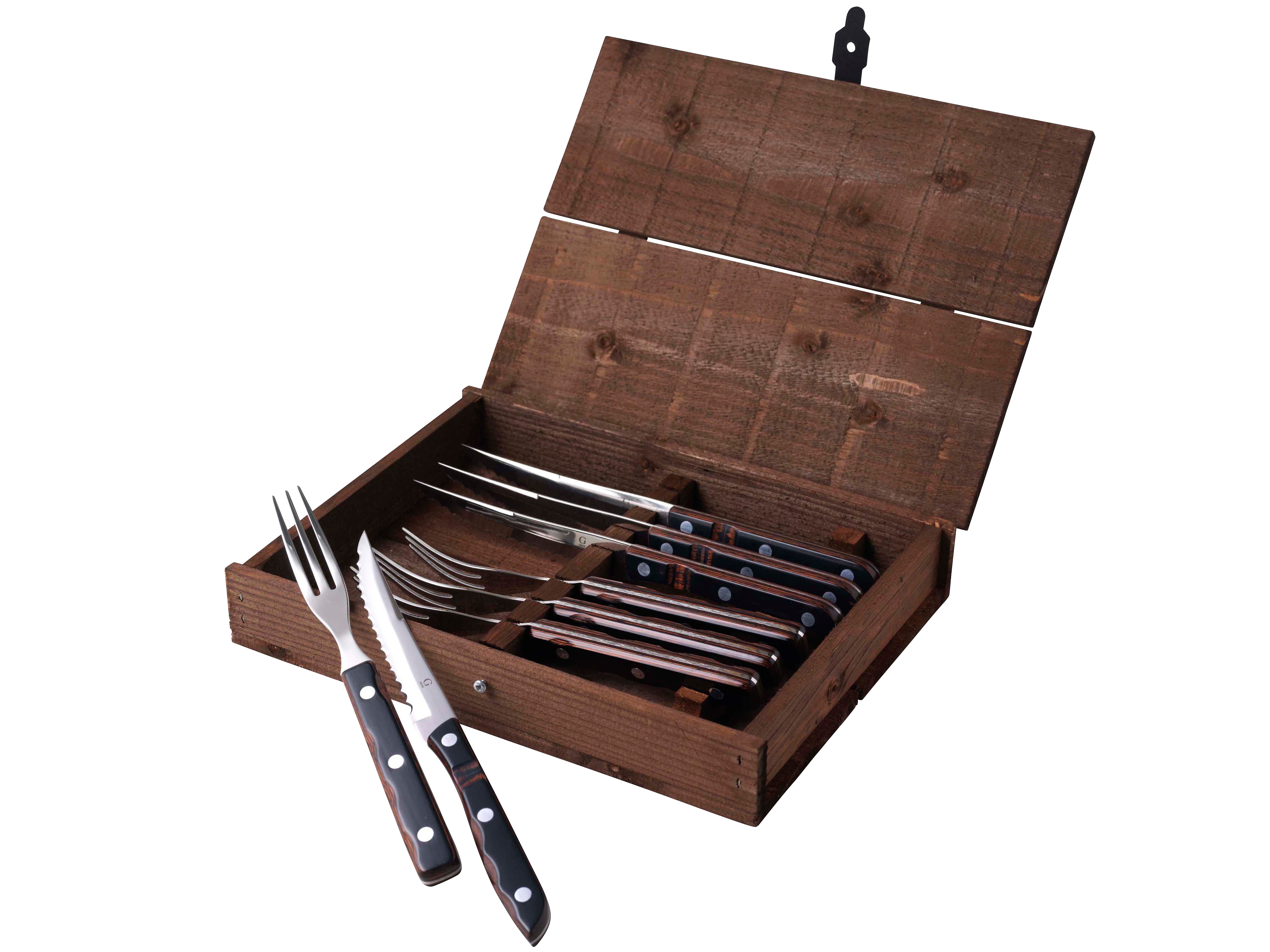 Billede af en åben trækasse med klassisk steakbestik og grillbestik fra Gense Old Farmer indeholdende fire knive og fire gafler i rustfrit stål med sorte håndtag og hvide prikker