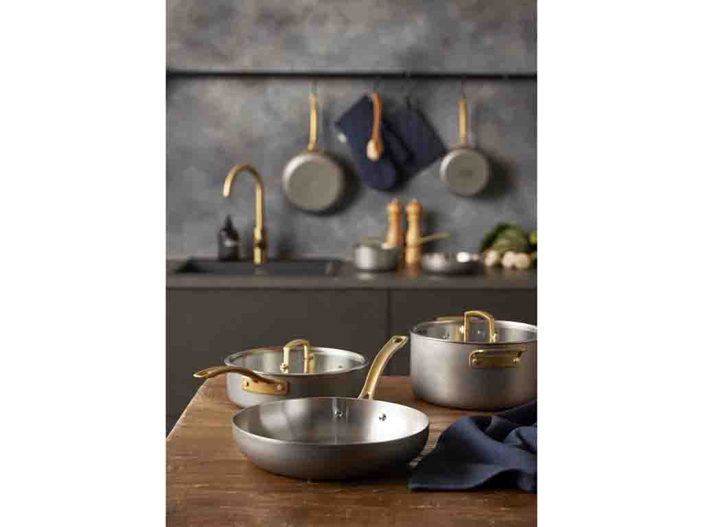 Billede af Pillivuyt Gourmet Durance kasserolle med låg i rustfrit stål med en diameter på 18 cm og en kapacitet på 2 liter sammen med en stegepande og en gryde i et moderne køkkenmiljø med brune træoverflader og en grå baggrund