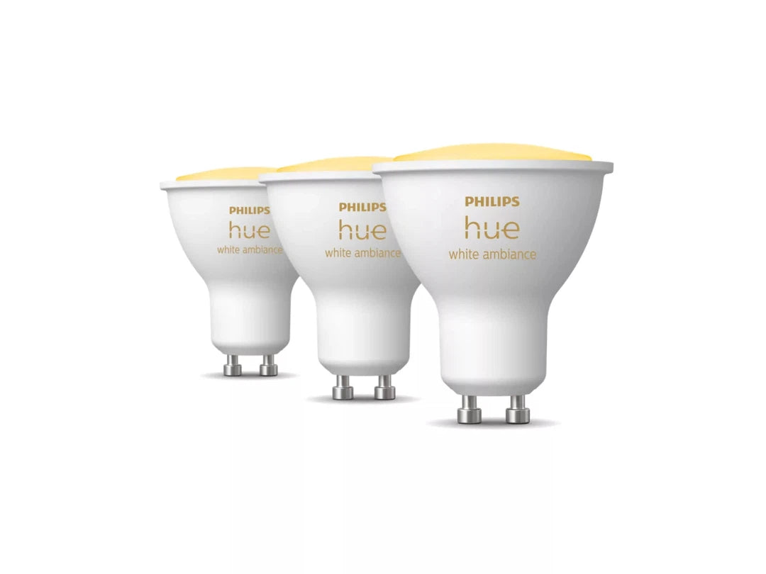 Tre Philips Hue White Ambiance GU10 Bluetooth pærer i hvidt design med en let afrundet form og en gylden top der angiver lysstyrke og ambiance muligheder