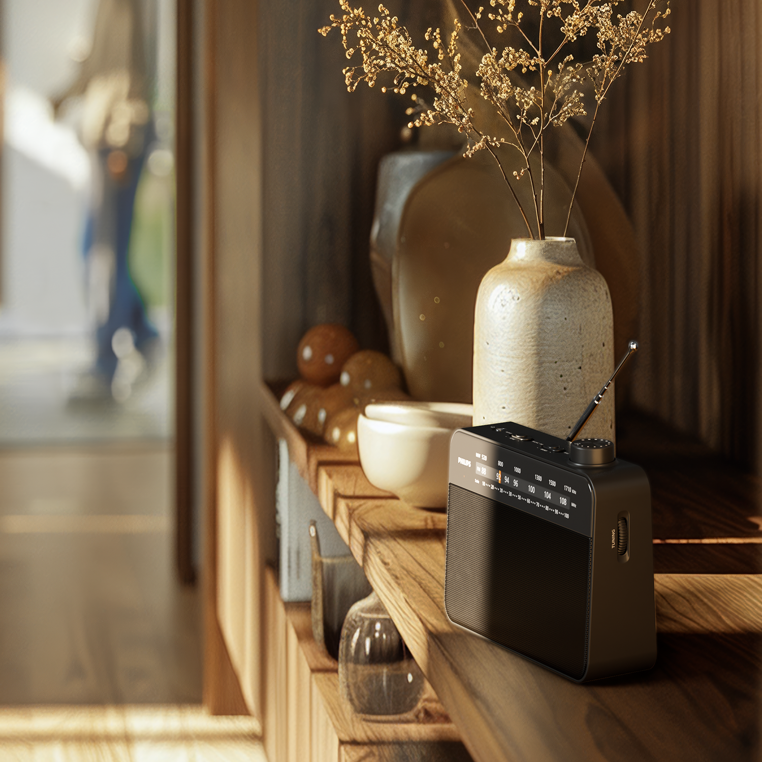 Philips TAR2509/10 FM radio placeret på en træhylde ved siden af dekorative genstande og en vase med tørrede blomster i et lyst indendørs miljø