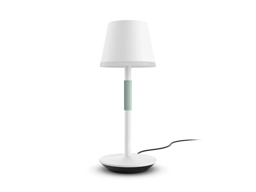 Bærbar bordlampe fra Philips Hue Go i hvid farve med en grøn midterdel og rund base, designet til at skabe stemningsfuld belysning i hjemmet