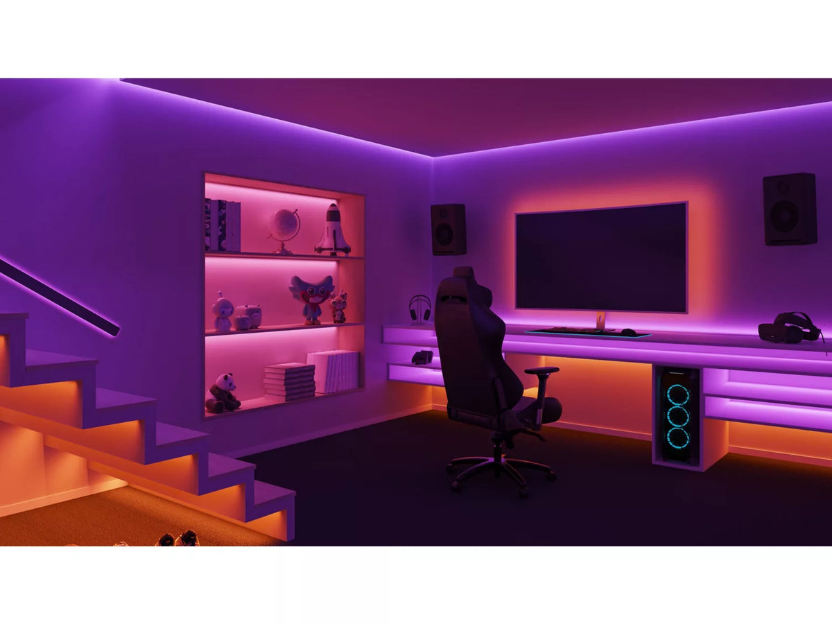 Philips HUE Solo lysstribe på tre meter i et moderne hjemmebiografmiljø med lilla og orange belysning der fremhæver en skrivebordsplads med gaming-stol, computerudstyr og hylder fyldt med nips.