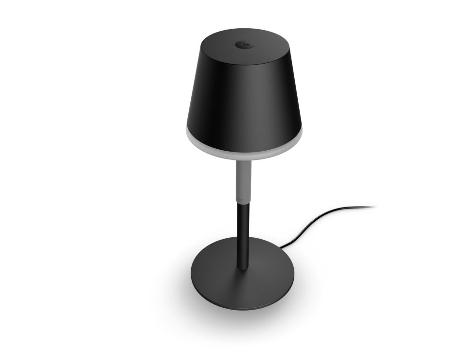 Bærbar bordlampe Philips Hue Go i sort farve med en cylindrisk skærm og en rund fod samt en ledning der strækker sig fra lampen