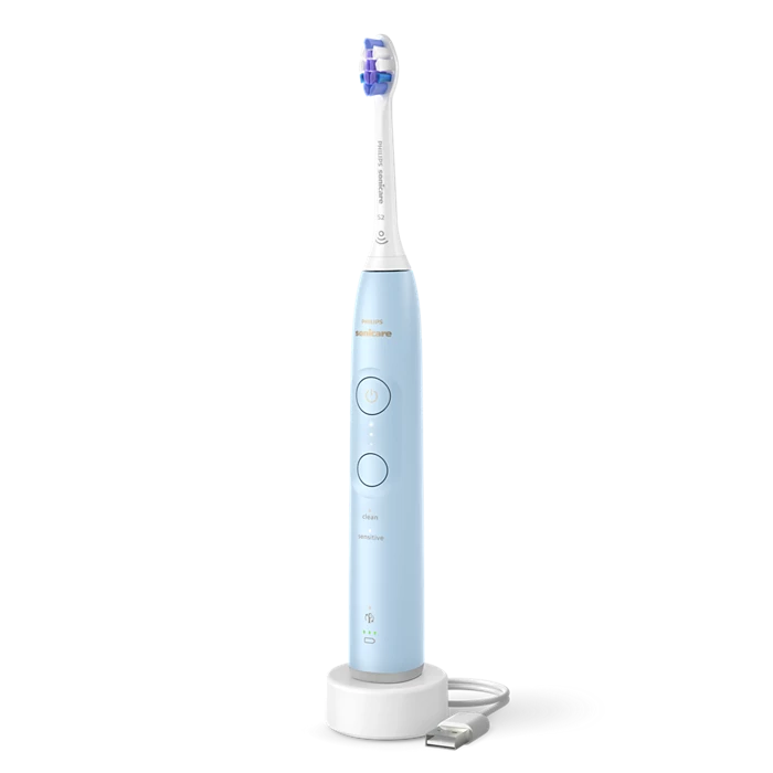 Eltandbørste fra Philips Sonicare Serie 6100 i lyseblå farve med en børstehovede og et genopladeligt design stående på en hvid oplader med synlige kontrolknapper og indikatorlys