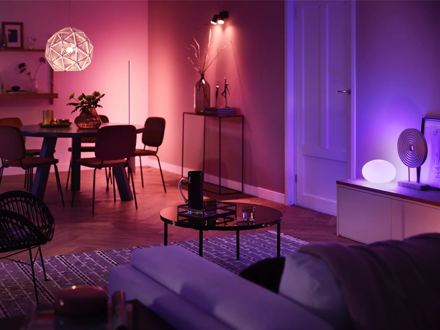 Philips Hue Startsæt med 2 E27 pærer der giver 1100 lumen lysstyrke samt en dimmer switch i et moderne indrettet stueområde med bløde farver og elegant belysning