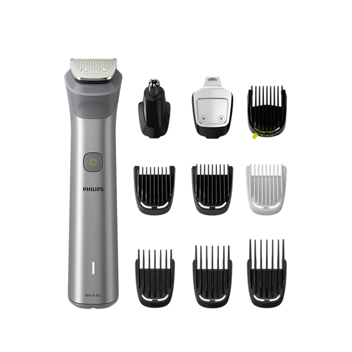 Philips Multitrimmer All-in-one Serie 5000 MG5920/15 med en slank sølvfarvet krop og en startknap samt oplader og forskellige klippeskær til justering af længden ligger grupperet omkring den centrale enhed