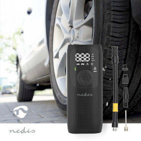 Nedis genopladelig luftkompressor med en trykområde fra 0.1 til 10.3 Bar står ved siden af et bilhjul på en parkeringsplads kompressoren har en digital skærm og forskellige tilbehørskomponenter synlige ved siden af den.