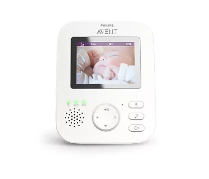 Digital babyalarm fra Philips Avent med video, viser en sovende baby på skærmen, enheden har knapper til lydstyrke og musikafspilning, designet i hvid farve.