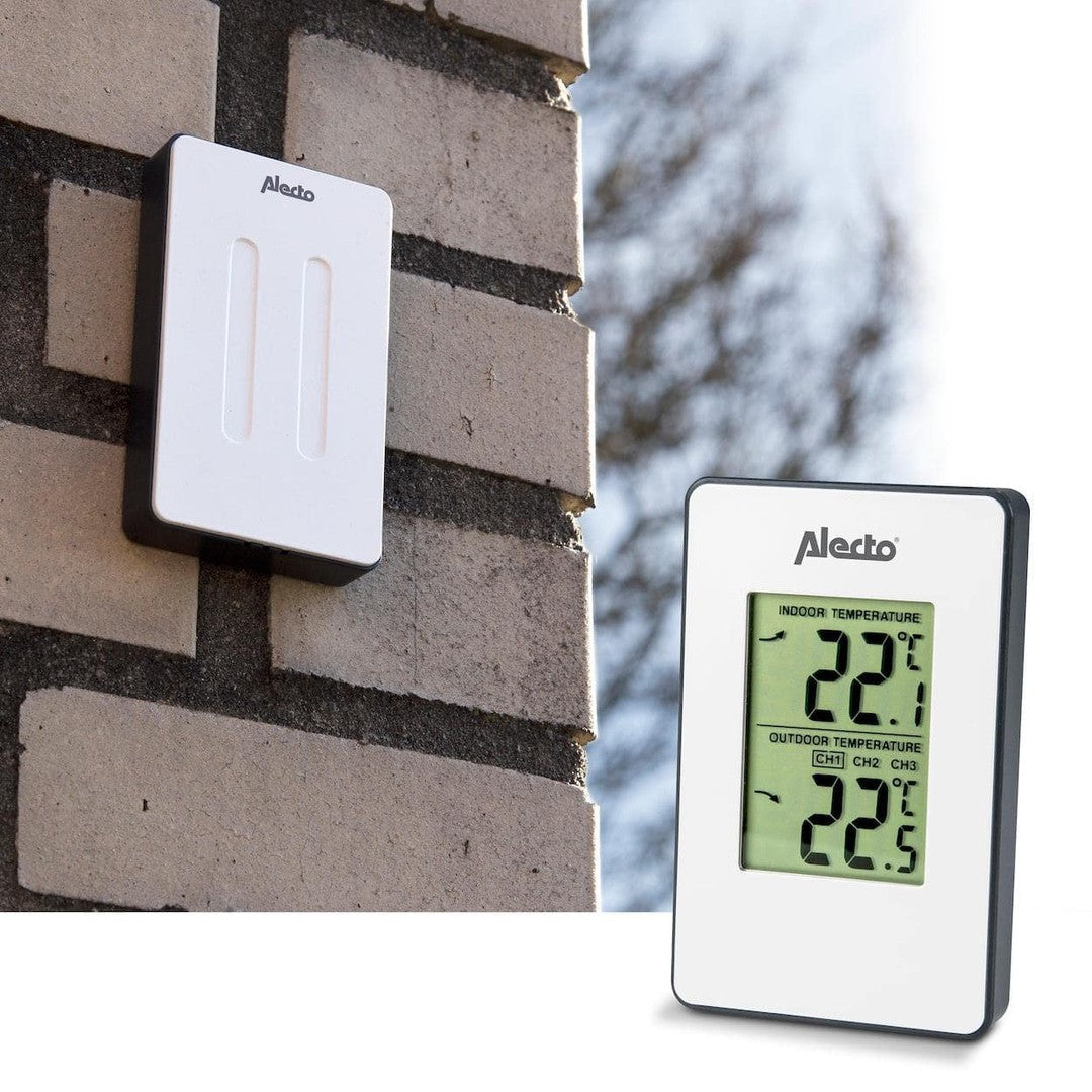 Trådløs sensor fra Alecto monteret på en mur og Alecto WS-1050 vejrstation der viser indendørs og udendørs temperaturer