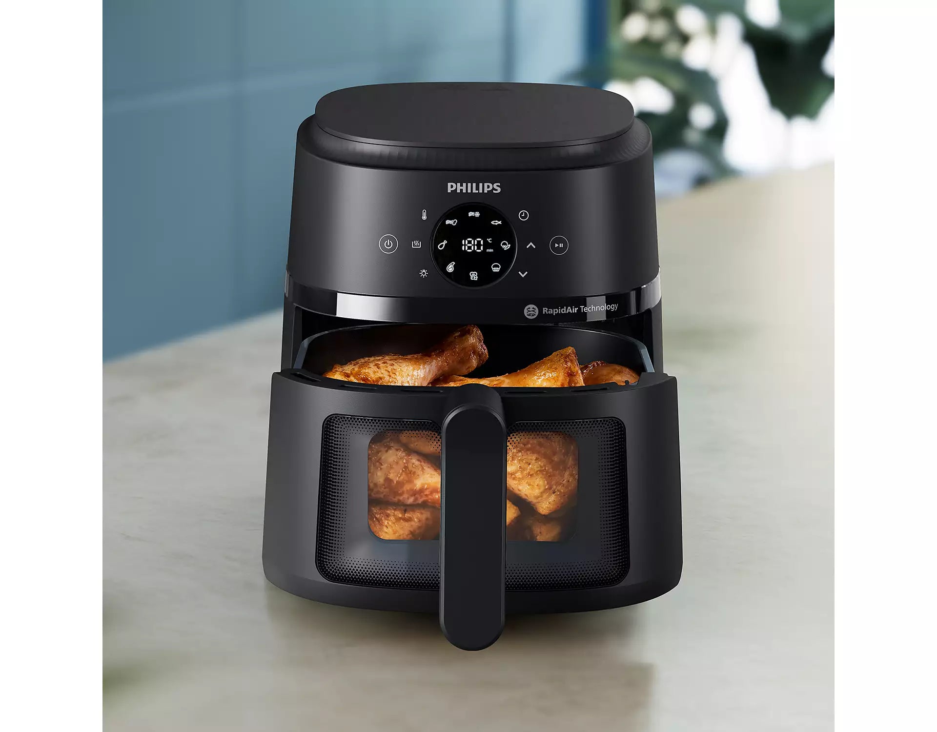 Philips NA220/00 Airfryer 2000 Series 4.2L med stegekurv der indeholder gyldne kyllingevinger og pommes frites på en køkkenbordplade i et moderne køkkenmiljø med kontrolpanel og knapper synligt i fronten