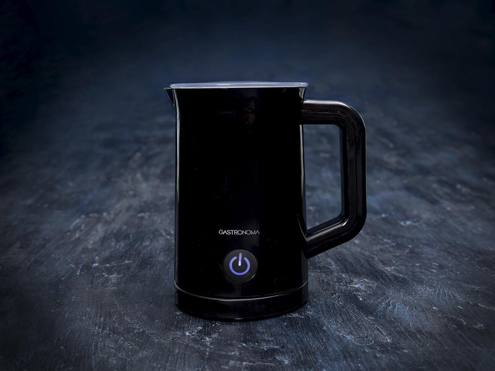 Sort mælkeskummer fra Gastronoma med en kapacitet på 0,3 liter og en effekt på 500 watt står på en mørk overflade med et minimalistisk design og en tænd/sluk-knap i bunden