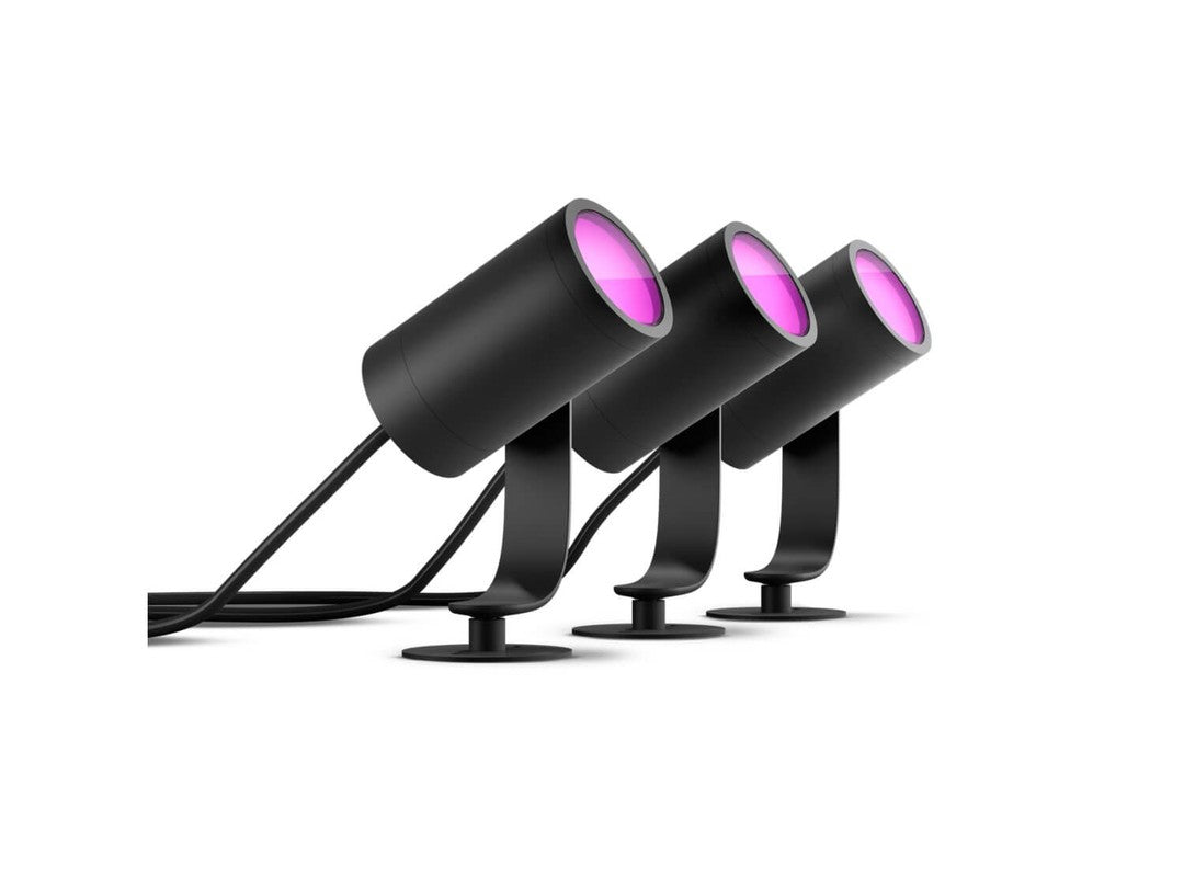 Tre Philips HUE Lily udendørsspots i sort med skarp pink belysning placeret på robuste fodstøtter, der gør dem velegnede til udendørs brug.