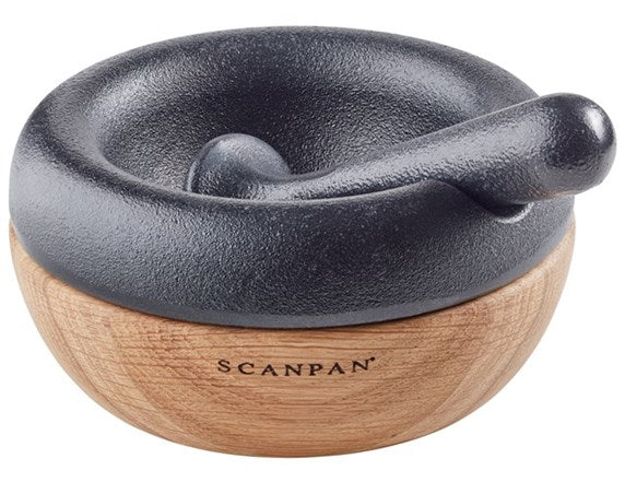 Morter med støder fra Scanpan i 10 cm størrelse med sort støbejern og træbund designet til effektiv knusning af krydderier og urter
