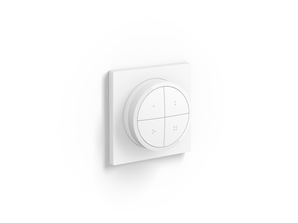 Philips Hue Tap dial switch i hvid med en rund kontrolknap opdelt i fire sektioner på en firkantet base monteret på væggen