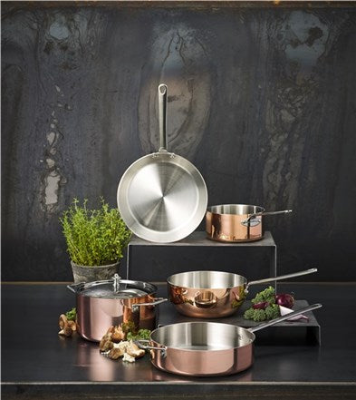 Scanpan 24 cm sauterpande i kobber med en pæn stålhåndtag og moderne design præsenteret sammen med forskellige gryder og et krydderurtearrangement i en stilfuld køkkenindretning